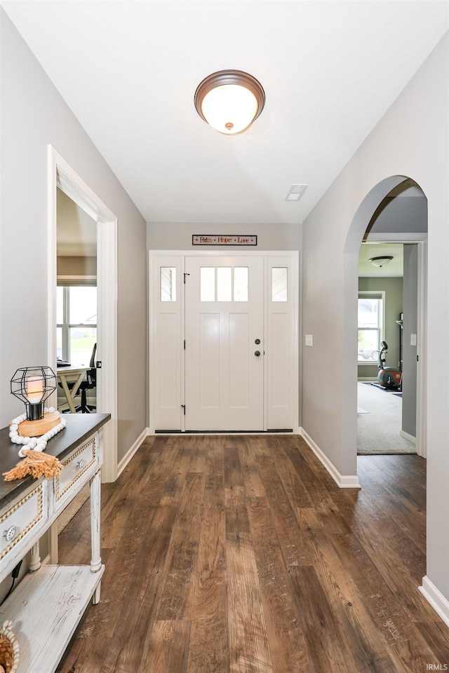 13865 Escondida Cv, Fort Wayne, IN 46845 - foyer entrance with arched walkways, dark wood-style floors, and baseboards