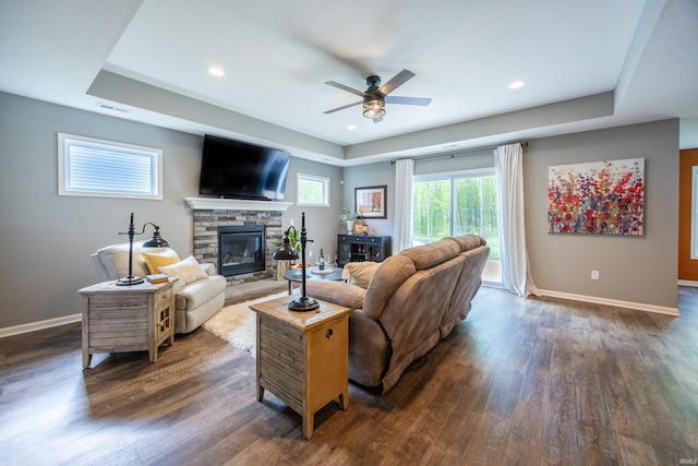 13865 Escondida Cv, Fort Wayne, IN 46845 - living room with a tray ceiling, a fireplace, dark wood-style flooring, a ceiling fan, and baseboards