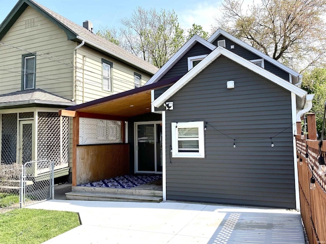 rear view of property with a wooden deck and fence