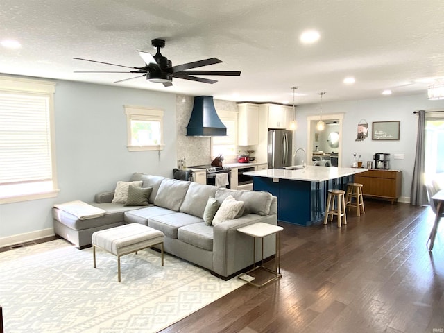 living room featuring a ceiling fan, dark wood-style flooring, baseboards, recessed lighting, and a textured ceiling