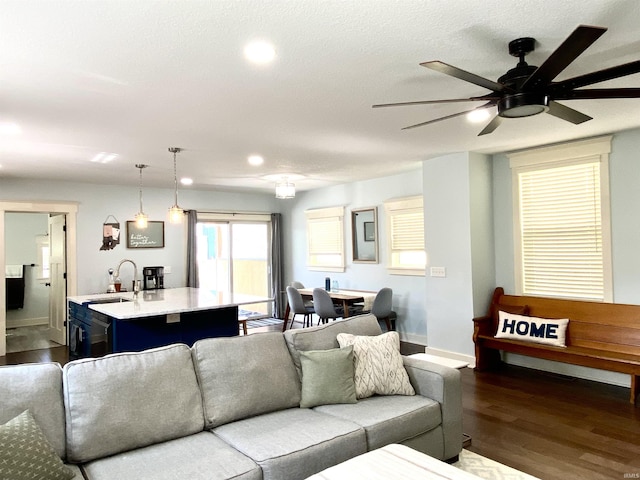 living room featuring dark wood-style floors, ceiling fan, baseboards, and recessed lighting