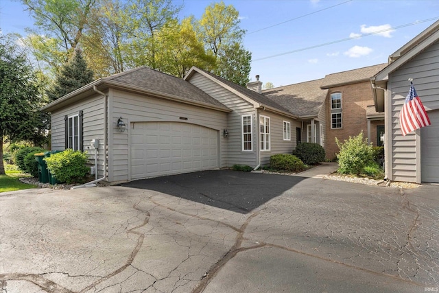 3821 Emerald Bay St, Mishawaka, IN 46545 - view of front of home featuring a garage, driveway, a chimney, and roof with shingles