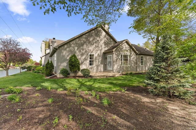 3821 Emerald Bay St, Mishawaka, IN 46545 - back of house with a chimney, a patio area, and a lawn