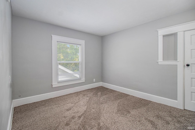 empty room with carpet and baseboards