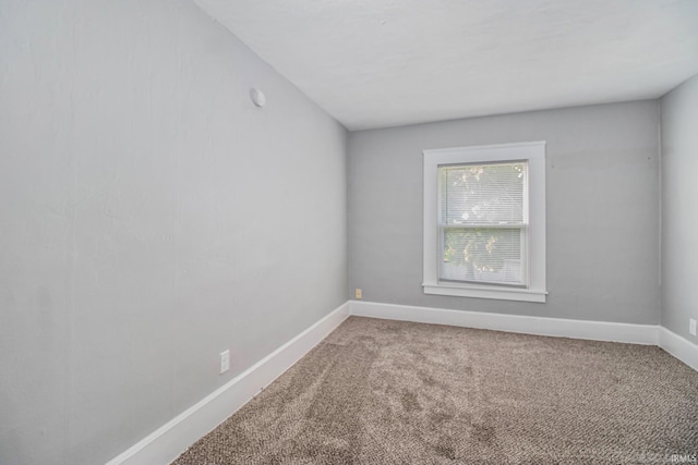 carpeted empty room featuring baseboards