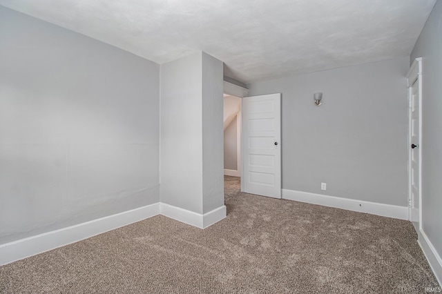 carpeted spare room with baseboards