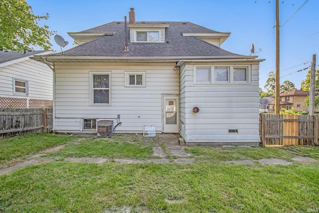 back of house with a shingled roof, central AC unit, and a chimney