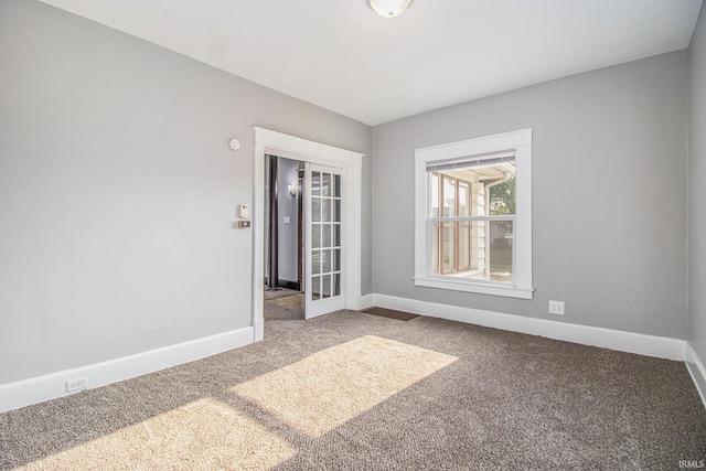 carpeted spare room featuring baseboards