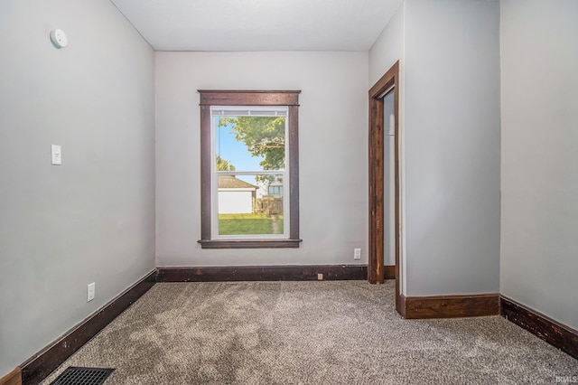 spare room with carpet flooring, baseboards, and a smoke detector