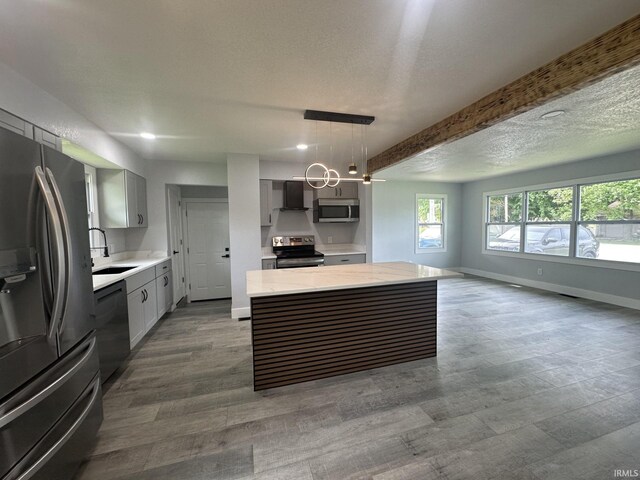 916 2nd Ave, Jasper, IN 47546 - kitchen featuring appliances with stainless steel finishes, wall chimney range hood, a kitchen island, gray cabinets, and a sink