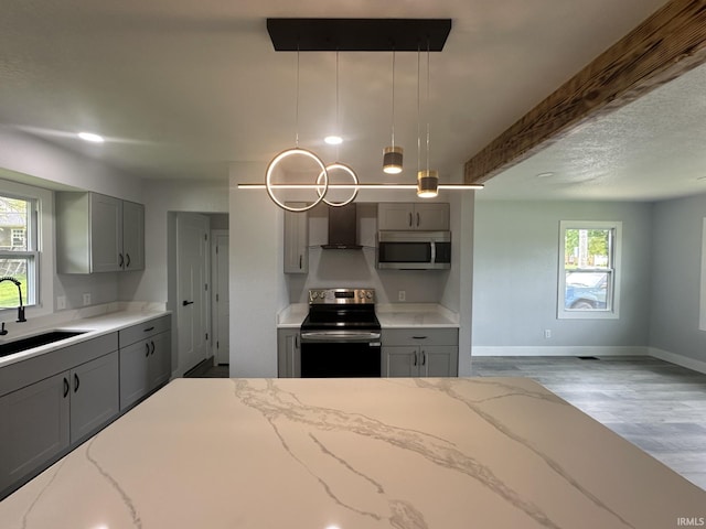 916 2nd Ave, Jasper, IN 47546 - kitchen with range with electric cooktop, gray cabinetry, stainless steel microwave, a sink, and wall chimney range hood