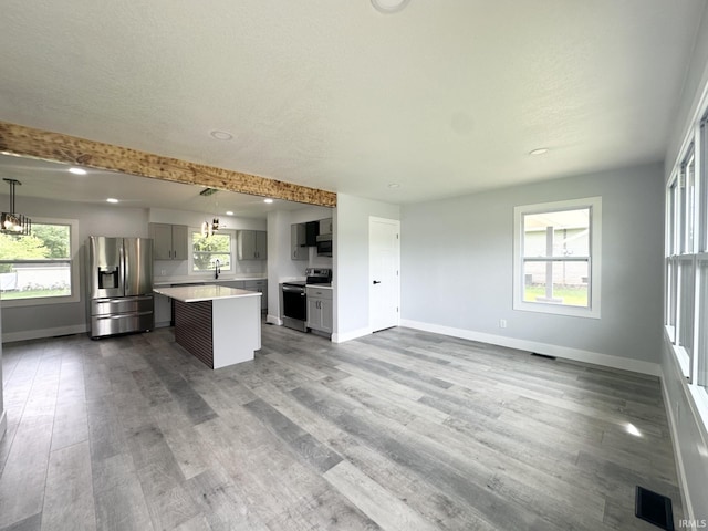 916 2nd Ave, Jasper, IN 47546 - kitchen with appliances with stainless steel finishes, a kitchen island, baseboards, gray cabinetry, and light countertops