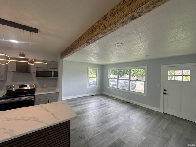 916 2nd Ave, Jasper, IN 47546 - kitchen featuring range with electric stovetop, stainless steel microwave, plenty of natural light, baseboards, and beamed ceiling