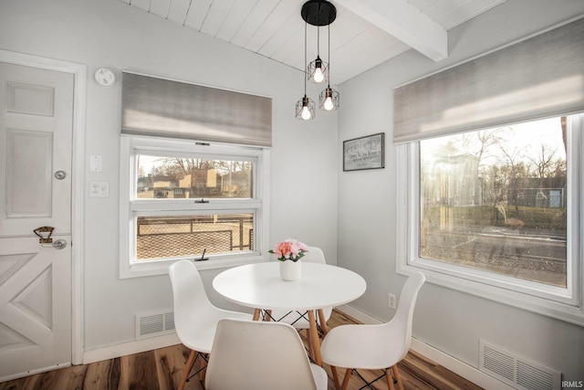 dining space with beamed ceiling and dark wood-type flooring