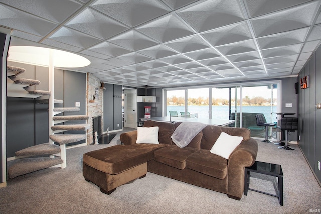 living room featuring carpet floors, stairs, and a water view
