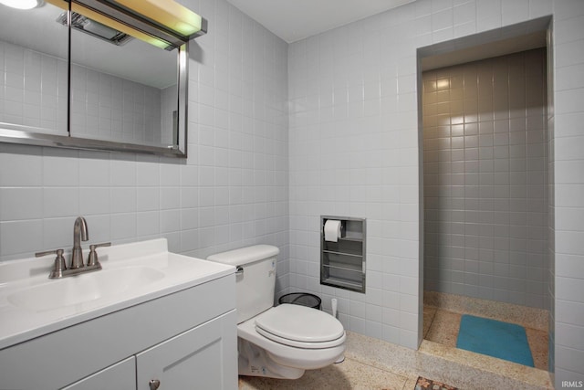 full bathroom with tile walls, toilet, walk in shower, and vanity