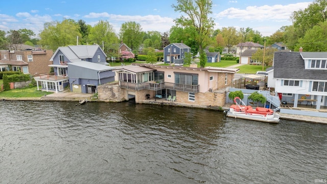 back of property with a residential view and a water view