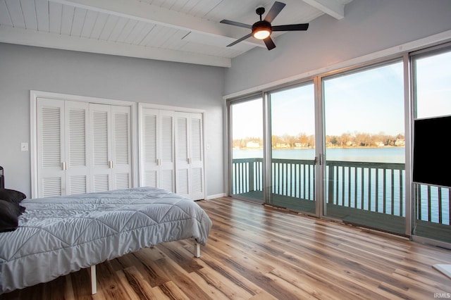 bedroom with access to exterior, wood finished floors, two closets, and ceiling fan