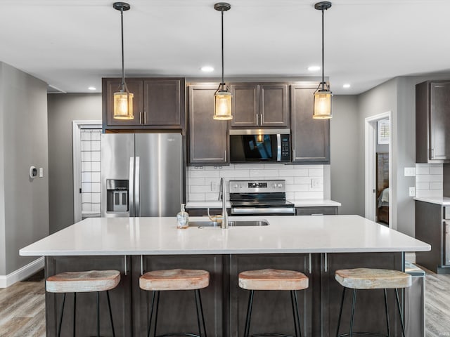 541 S Kelsey Ave, Evansville, IN 47714 - kitchen featuring appliances with stainless steel finishes, a sink, light wood-type flooring, decorative backsplash, and recessed lighting