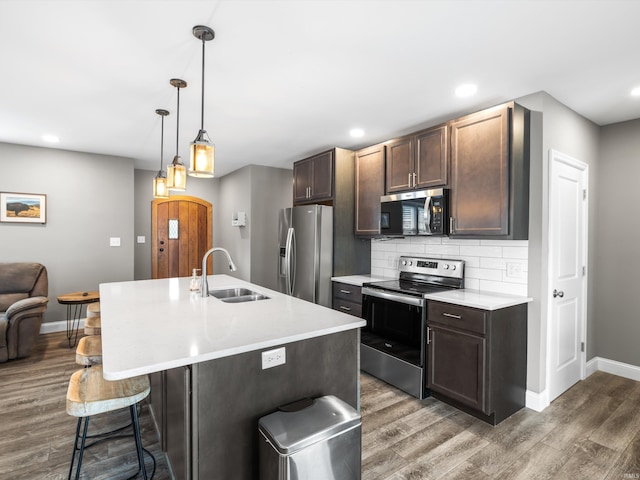 541 S Kelsey Ave, Evansville, IN 47714 - kitchen with appliances with stainless steel finishes, a sink, wood finished floors, baseboards, and a breakfast bar