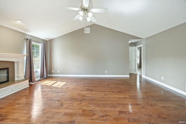 unfurnished living room featuring a ceiling fan, lofted ceiling, baseboards, and wood finished floors
