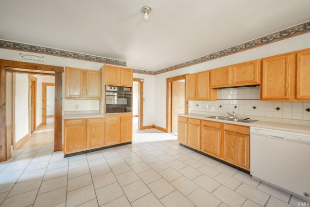 kitchen with white dishwasher, oven, a sink, backsplash, and light tile patterned flooring