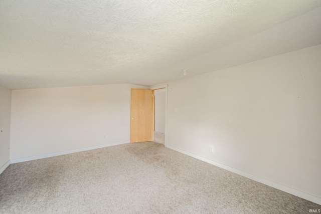 unfurnished room featuring light colored carpet, baseboards, and a textured ceiling