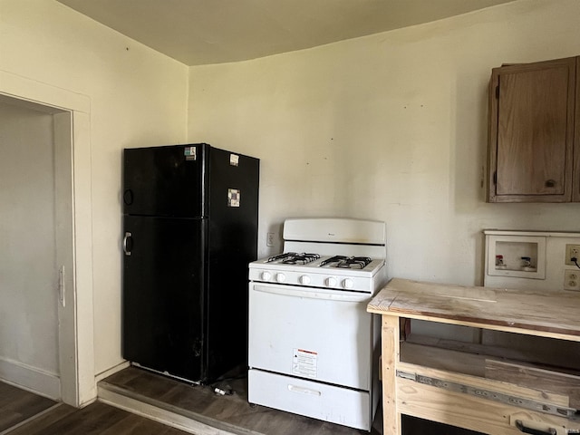 115 E 2nd St, Peru, IN 46970 - kitchen with freestanding refrigerator, white gas range oven, dark wood-style floors, and light countertops