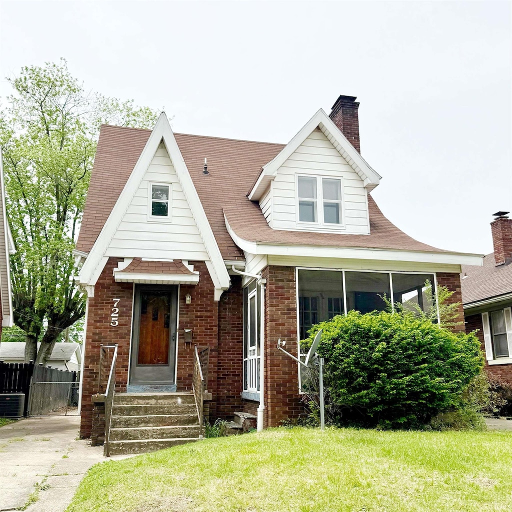 view of front facade with brick siding and a chimney