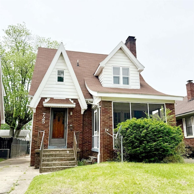 view of front facade with brick siding and a chimney