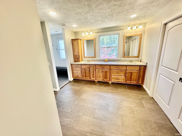 1700 W Taylor St, Kokomo, IN 46901 - full bath featuring baseboards, double vanity, stone finish flooring, and a textured ceiling