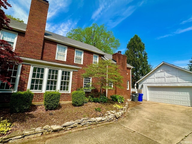 1700 W Taylor St, Kokomo, IN 46901 - view of side of home with a chimney, brick siding, an outdoor structure, and a garage