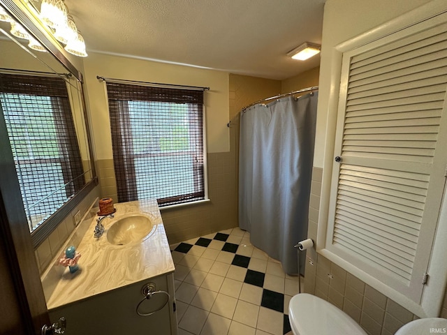 1700 W Taylor St, Kokomo, IN 46901 - bathroom featuring tile walls, toilet, vanity, tile patterned flooring, and a shower with curtain