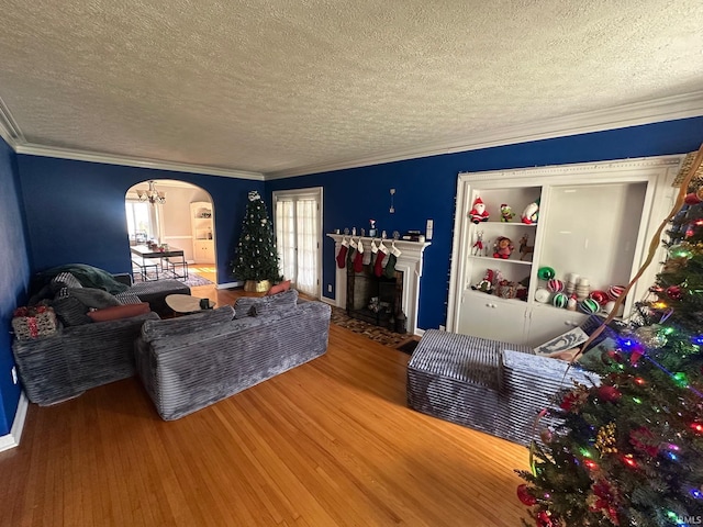1700 W Taylor St, Kokomo, IN 46901 - living area with a textured ceiling, arched walkways, wood finished floors, crown molding, and a fireplace with flush hearth