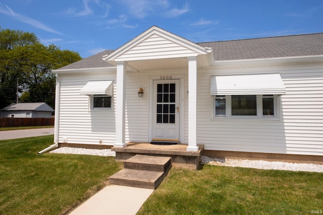 bungalow with roof with shingles and a front yard