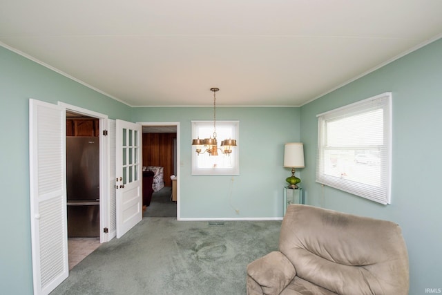 living area with healthy amount of natural light, carpet, a chandelier, crown molding, and baseboards