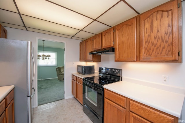 kitchen with black appliances, under cabinet range hood, light countertops, a paneled ceiling, and brown cabinets