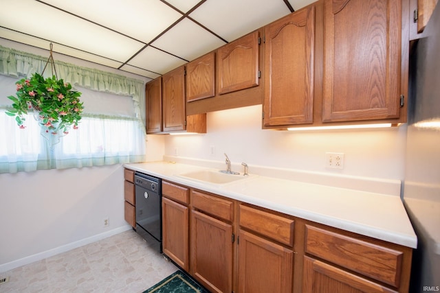 kitchen with black dishwasher, a sink, baseboards, light countertops, and brown cabinetry