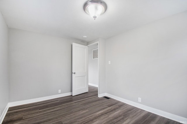 unfurnished room with dark wood finished floors and baseboards