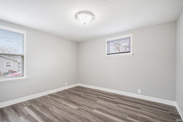 unfurnished room featuring dark wood finished floors and baseboards