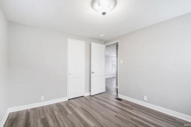 unfurnished bedroom featuring wood finished floors and baseboards