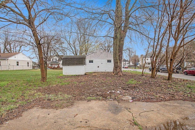 view of yard featuring a storage unit, an outdoor structure, and a residential view