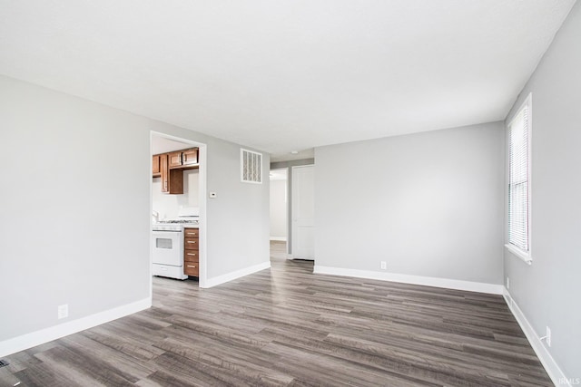 unfurnished living room with dark wood-style flooring and baseboards
