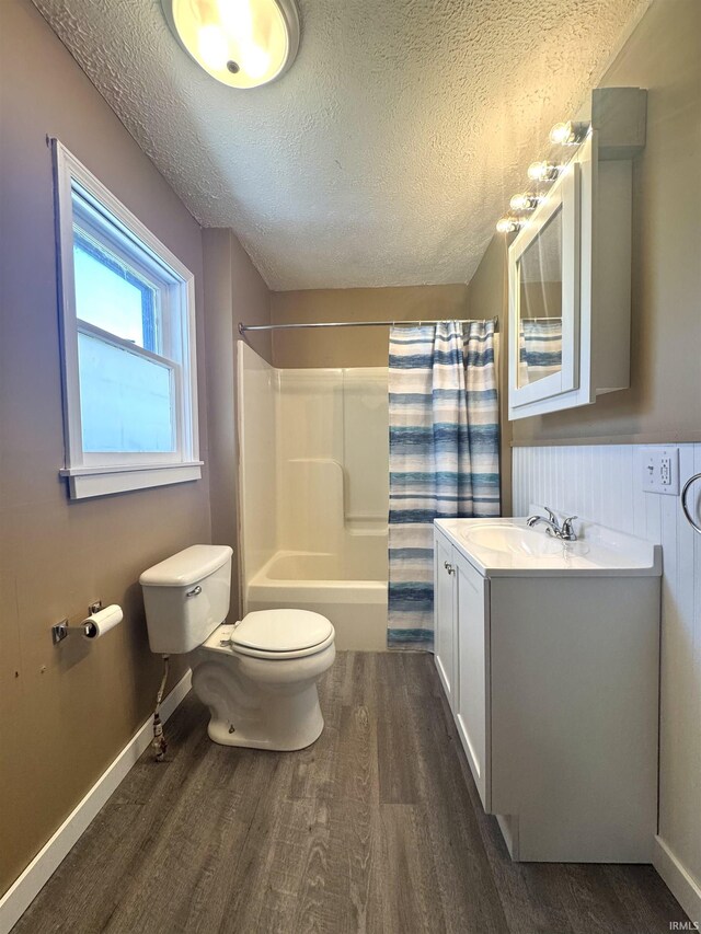 410 NW I St, Linton, IN 47441 - full bath with wood finished floors, toilet, a textured ceiling, vanity, and shower / bath combo with shower curtain
