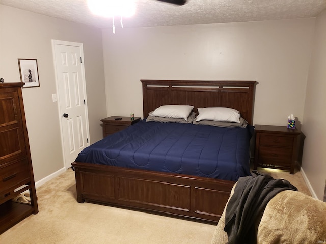 bedroom with carpet, a textured ceiling, baseboards, and a ceiling fan
