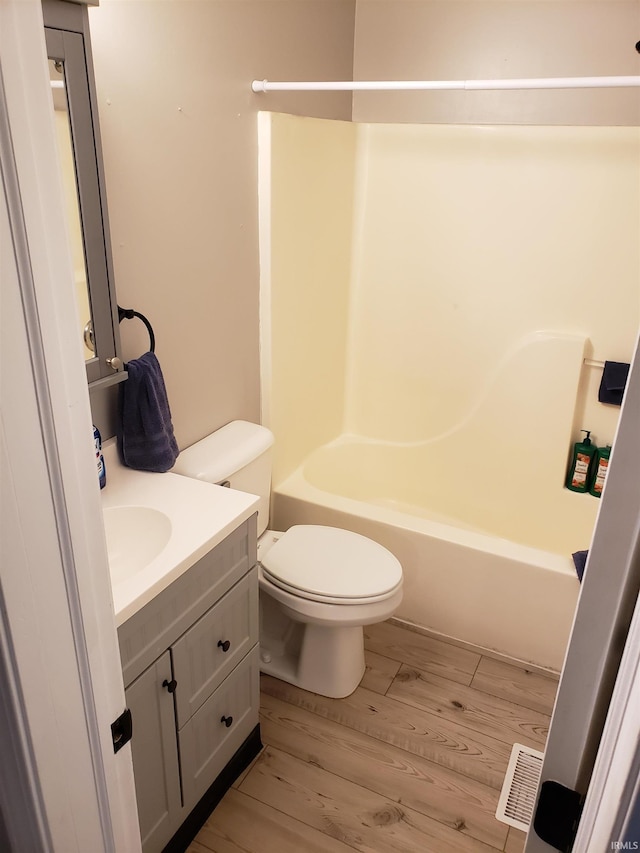 full bath with wood finished floors, toilet, vanity, and tub / shower combination