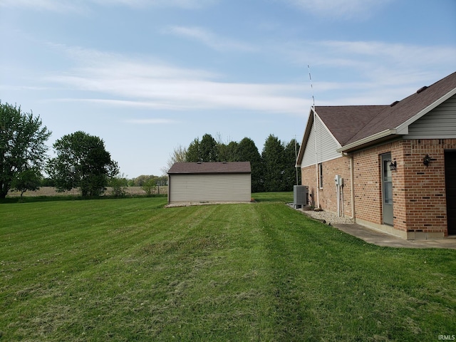 view of green lawn featuring central AC