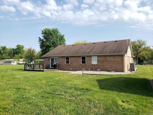 back of property with a lawn, brick siding, a wooden deck, and crawl space