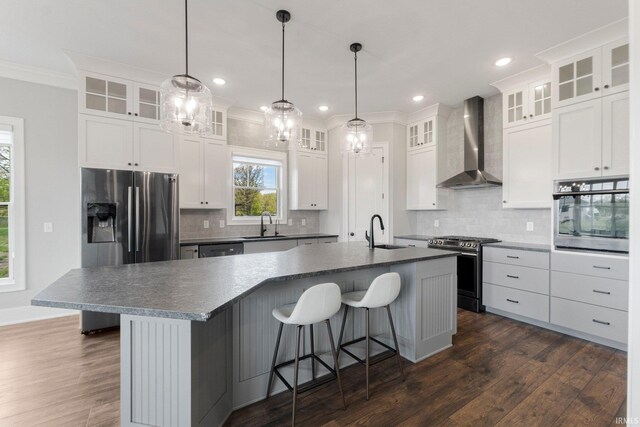 18015 Tullymore Ln, Leo, IN 46765 - kitchen featuring wall chimney range hood, stainless steel appliances, a sink, dark countertops, and ornamental molding