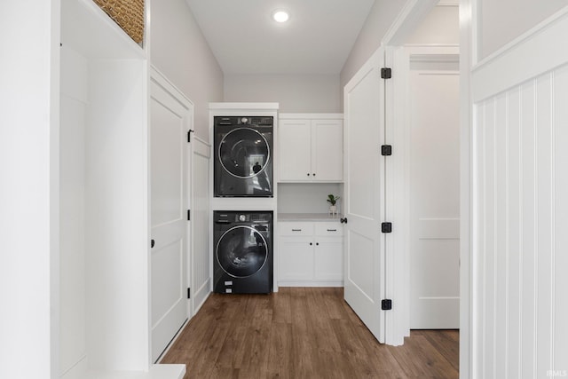 18015 Tullymore Ln, Leo, IN 46765 - clothes washing area with stacked washing machine and dryer, cabinet space, dark wood-style floors, and recessed lighting